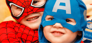 Children dressed in superhero costumes communicating